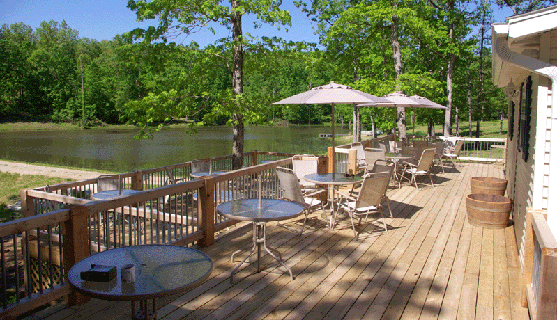 Twin Oaks Vineyard and Winery - outdoor photo, daytime, of a large wooden patio with patio furniture overlooking a lake.