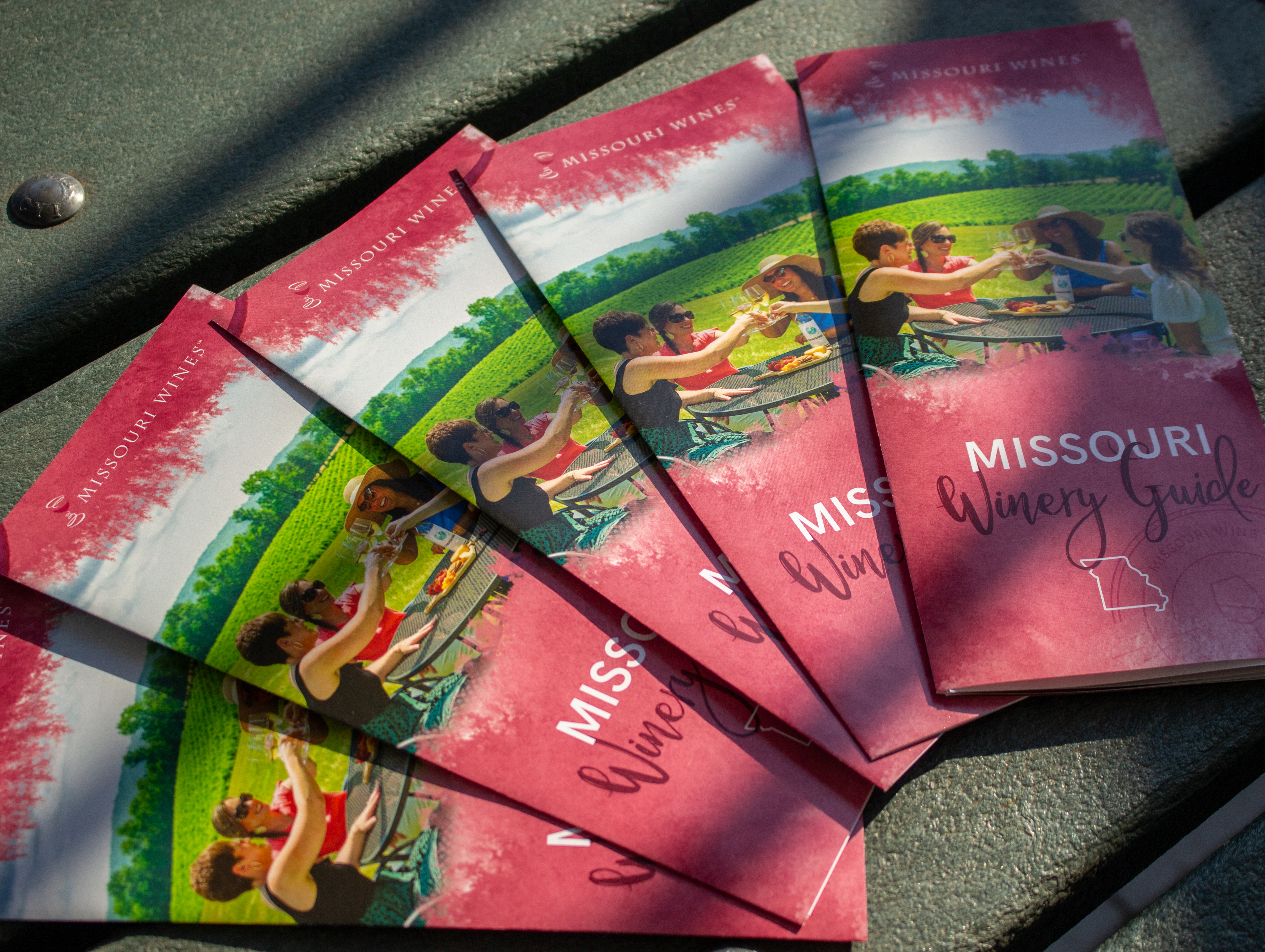 Wine guides stacked and spread out on a picnic table.