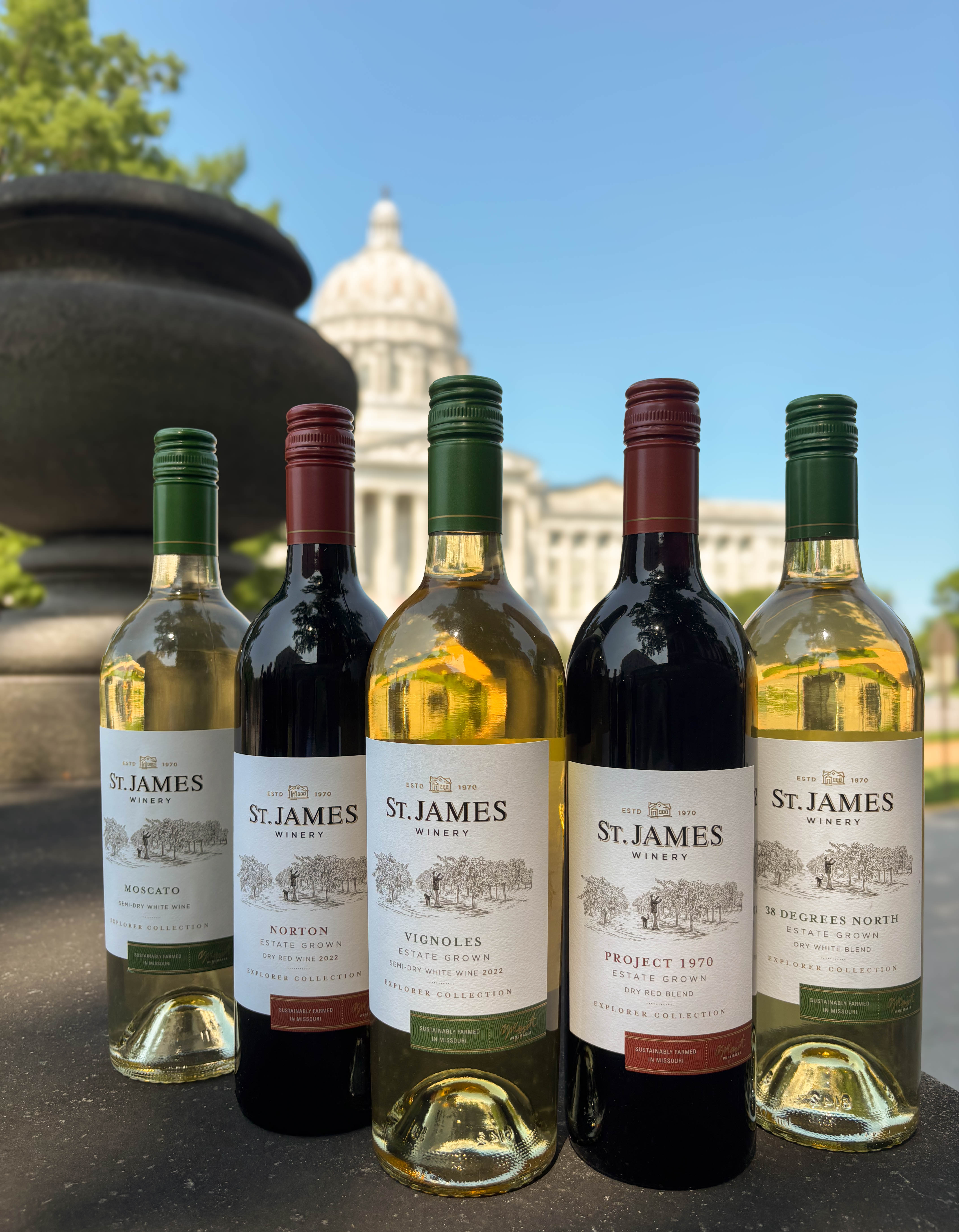 Wine bottle sitting on ledge in front of capital