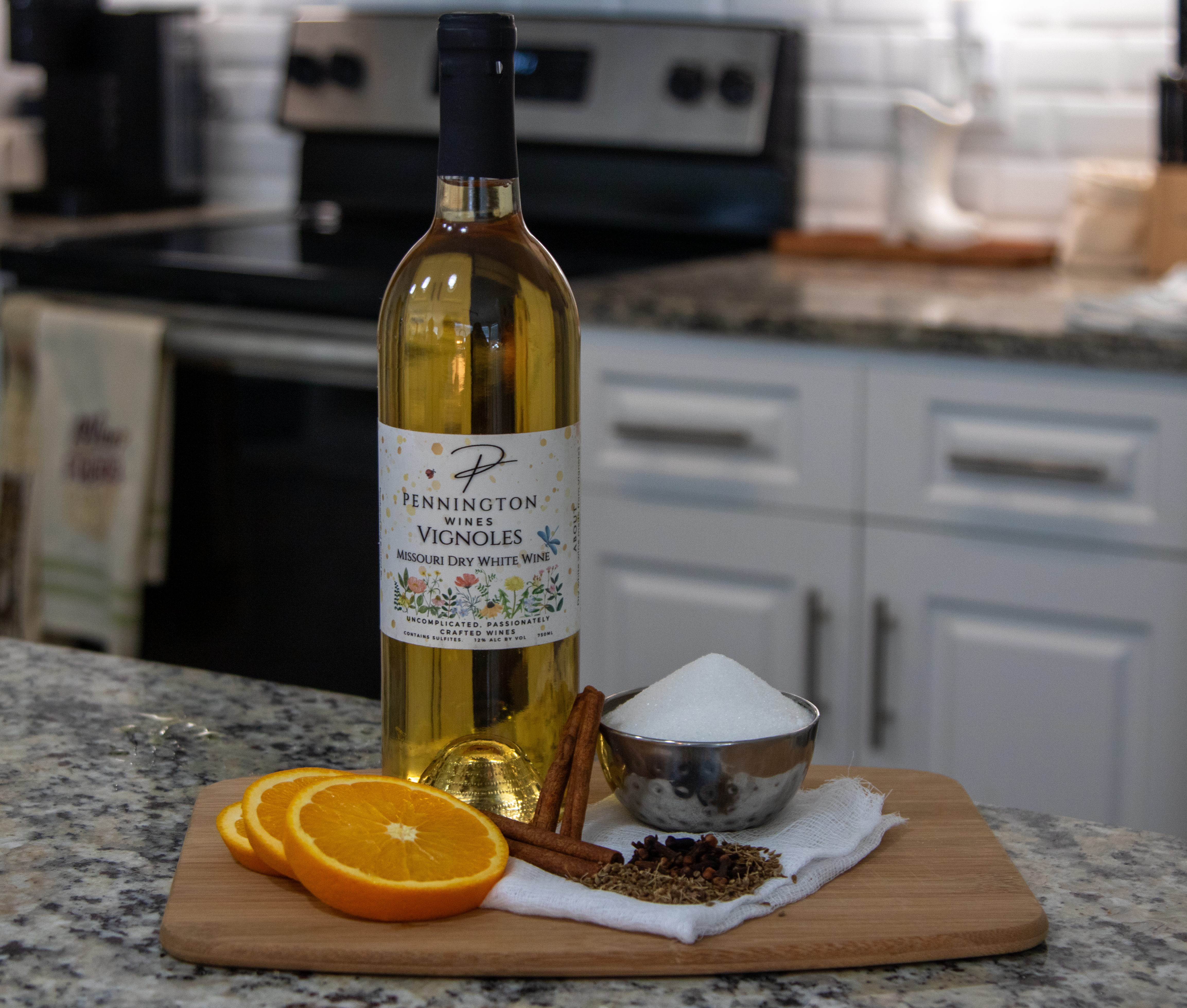 Missouri dry white wine, orange slices, mulling spices, cheese cloth, and sugar on cutting board.