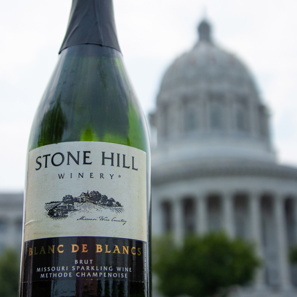 Bottle of Blanc de Blancs from Stone Hill outside with the MO state capital dome in the background