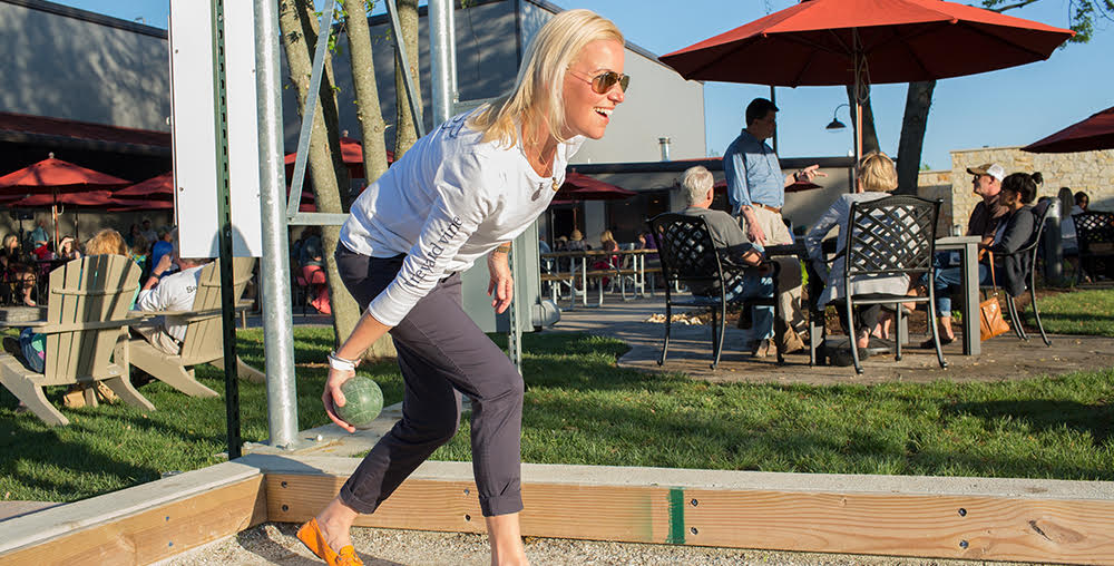 Woman playing bocce outside at the Saint James Winery Gardens